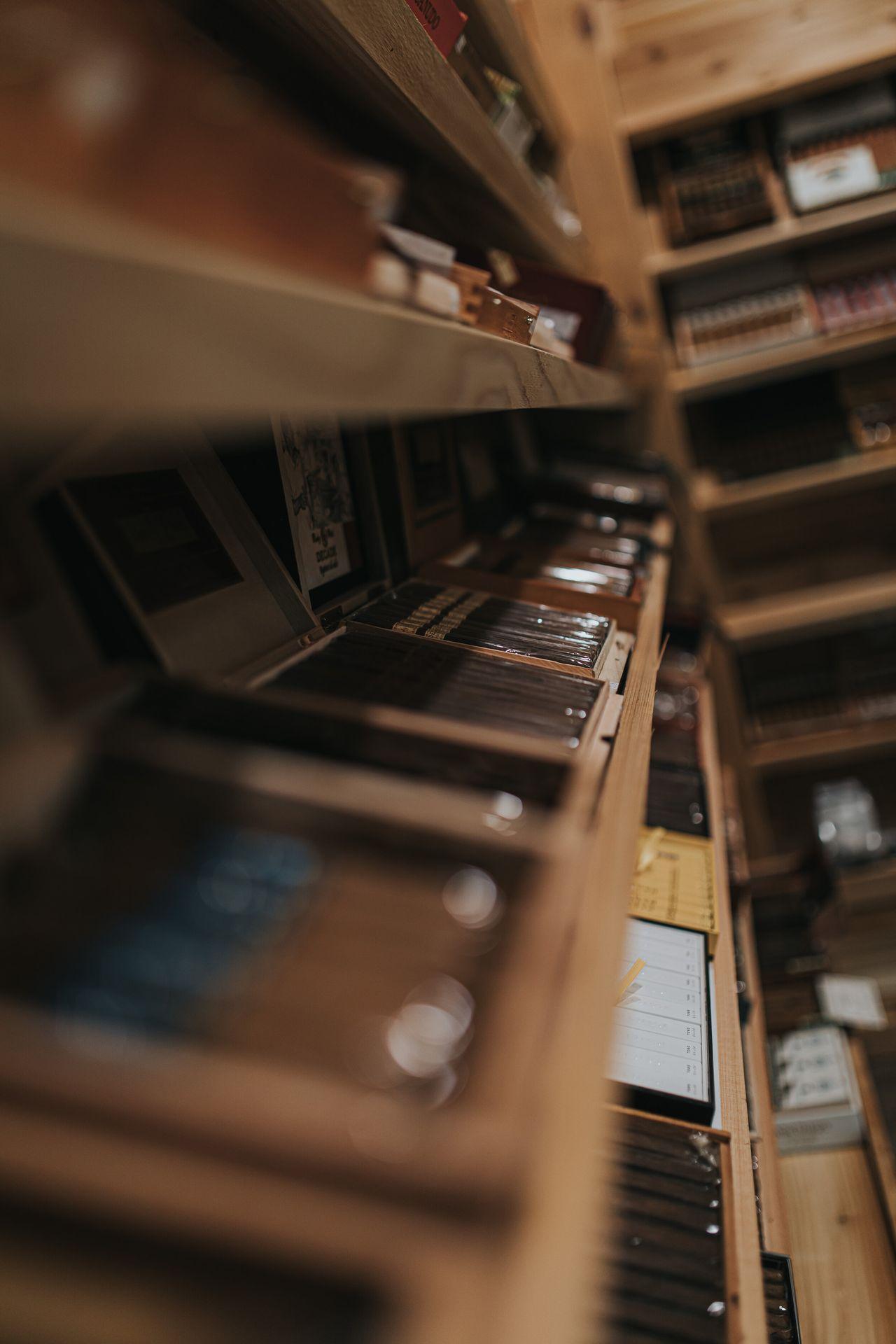 Close-up view of shelves filled with various types of cigars in a wooden storage unit.